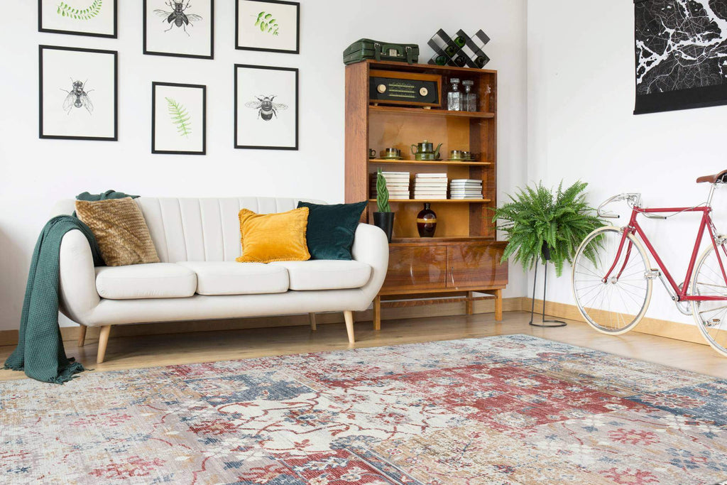 Ein rechteckiger bunter Teppich in Vintage Look liegt in einem Wohnzimmer.