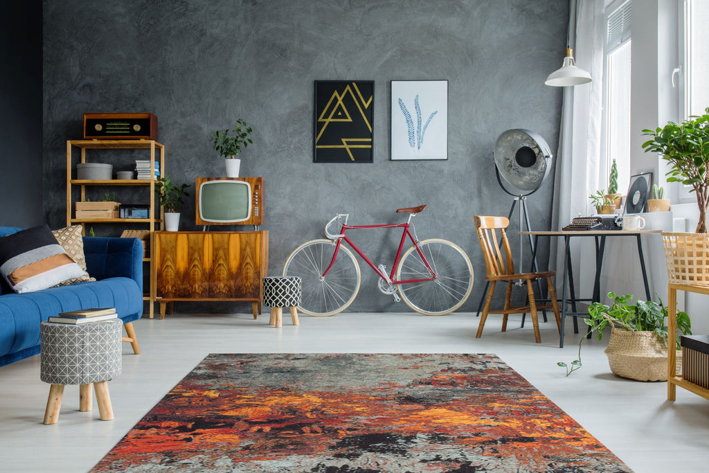Ein rechteckiger Teppich in bunte Farben mit Abstract Mustern bedeckt den Boden eines Wohnzimmers.